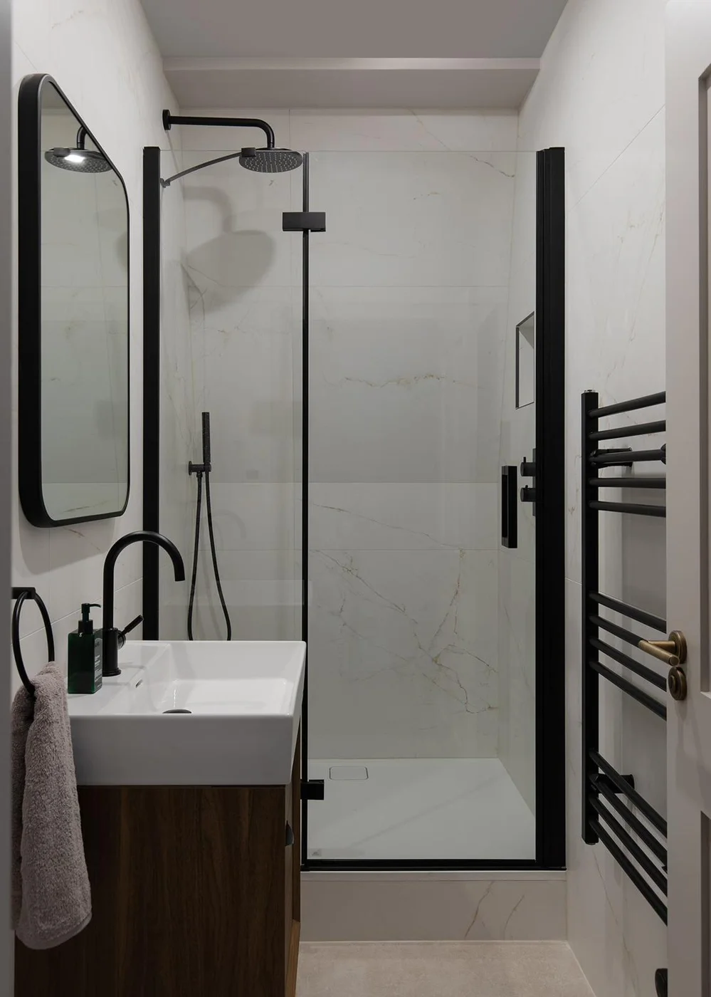 Narrow shower room with a glass screen and black fittings