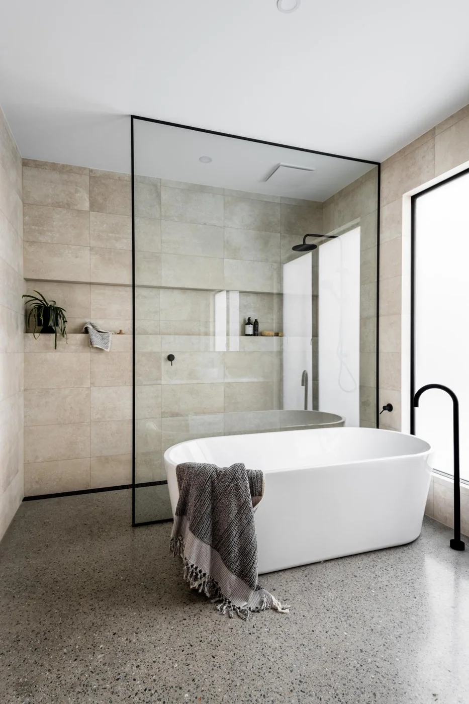 Neutral bathroom with a glass shower enclosure and freestanding bath
