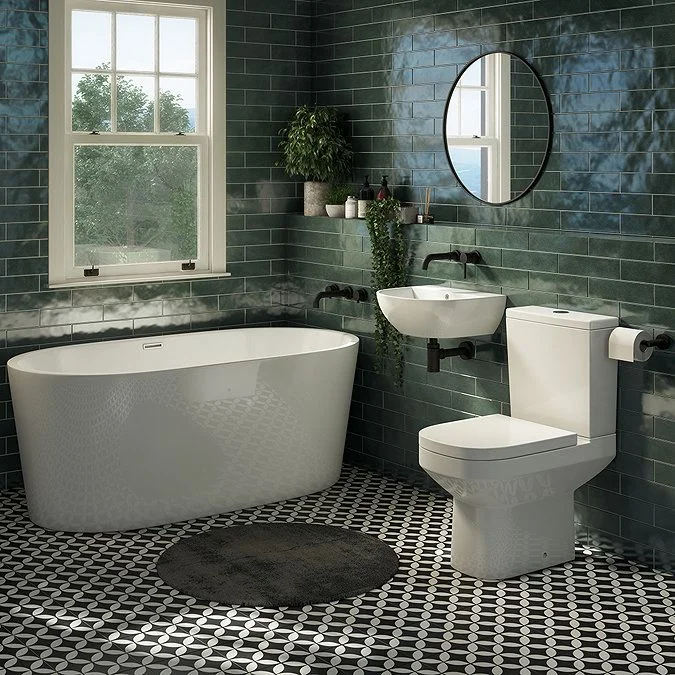 Green tiled bathroom with a curved bath and white basin