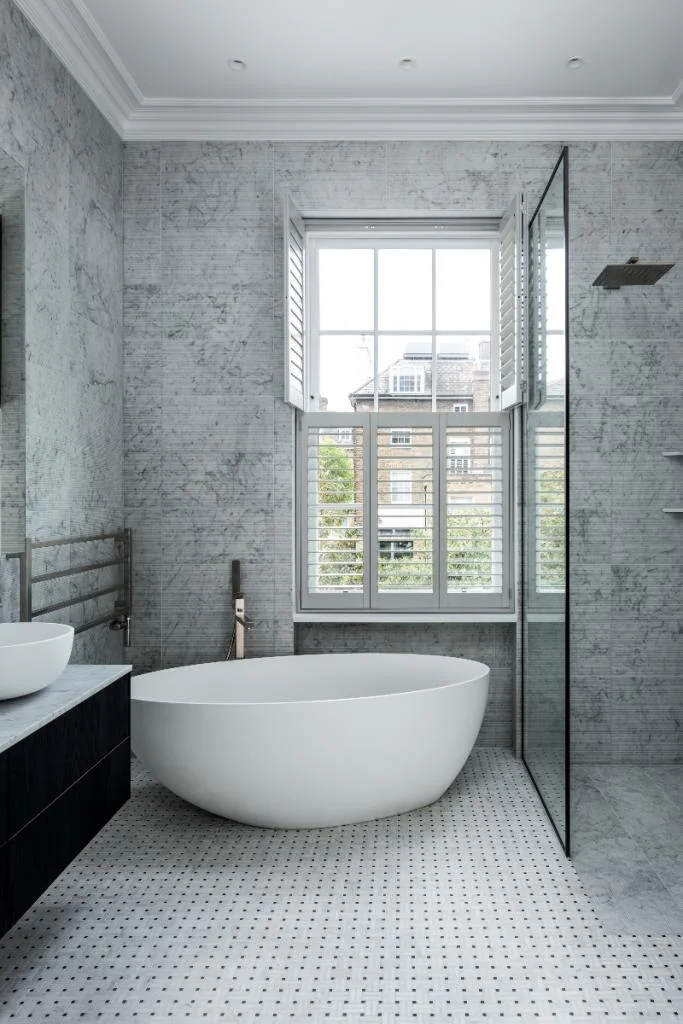 Grey bathroom with a freestanding bath and enclosed shower